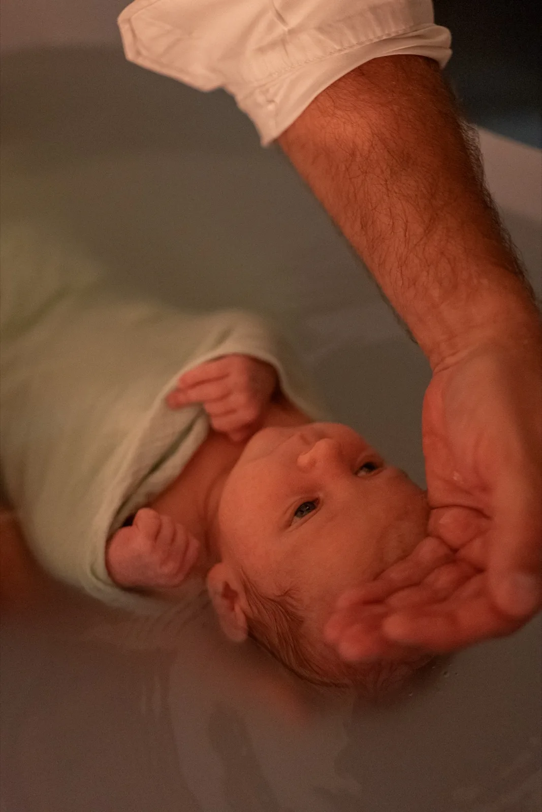 Moment de complicité parent-bébé pendant un bain enveloppé