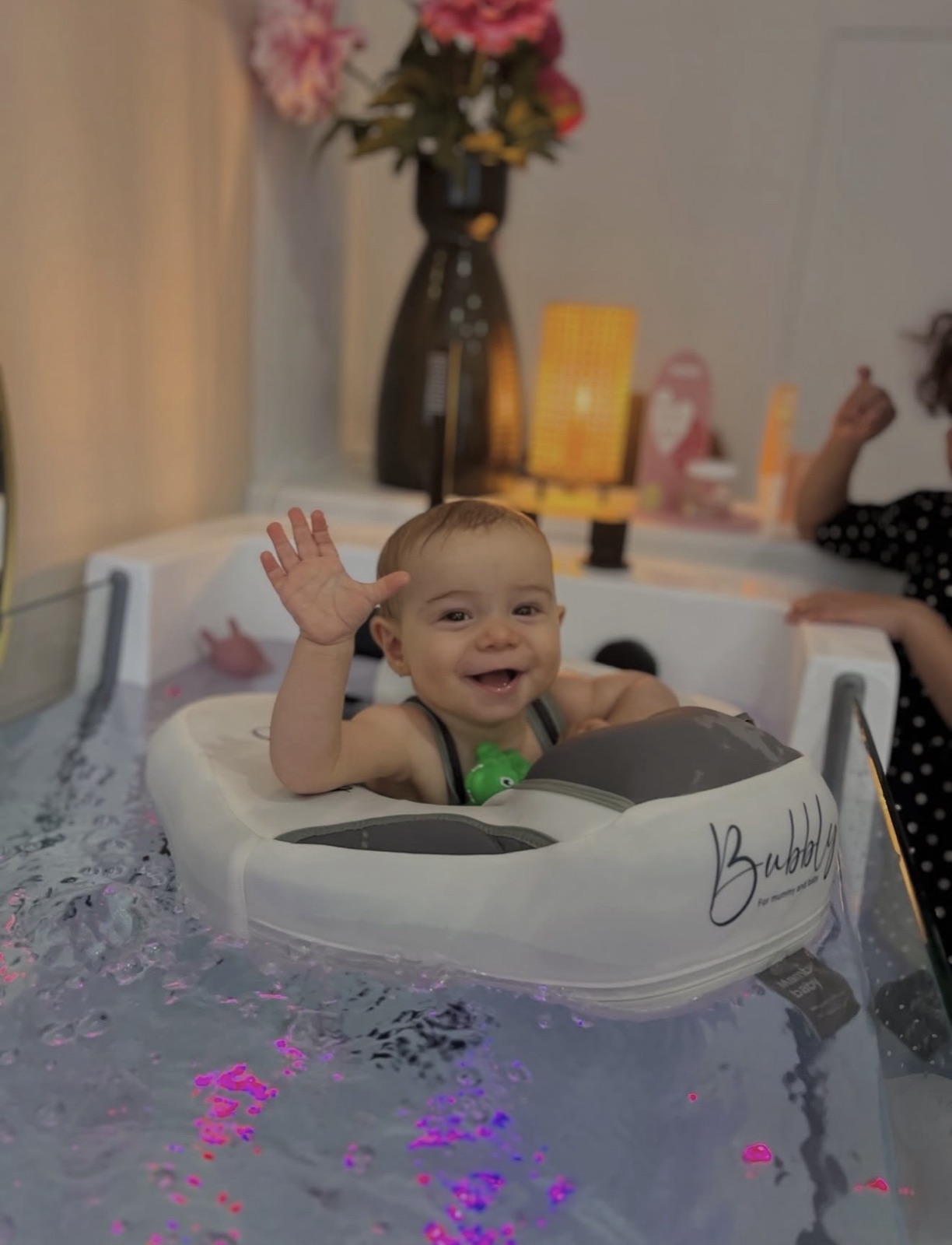 Bébé qui salue de la main pendant sa séance d'hydrothérapie chez Bubbly